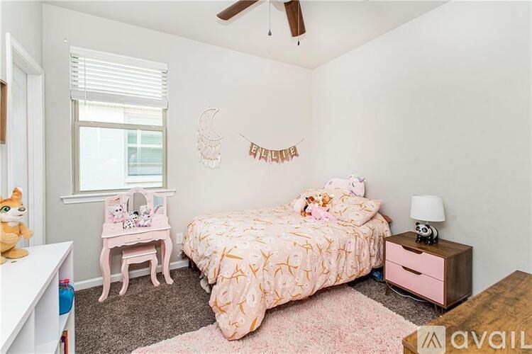 A bedroom with a bed, nightstand, and a window with blinds.