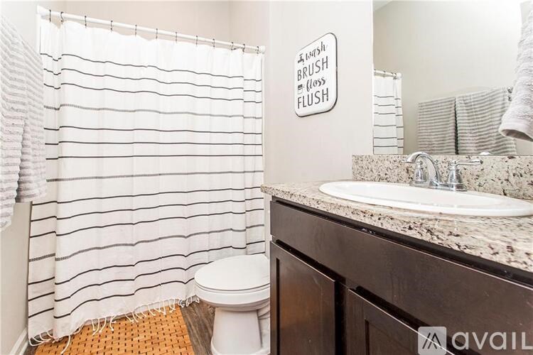 A bathroom with a toilet, sink, and a shower curtain.
