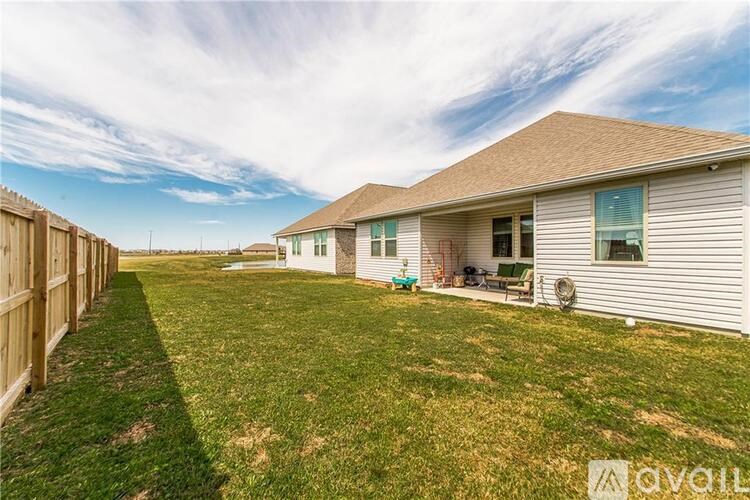 A house with a fence and a lawn in front of it.
