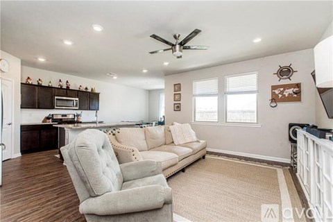 A living room with a white couch and a ceiling fan.