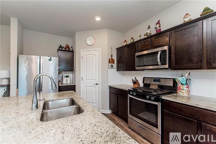 A kitchen with granite countertops and dark wood cabinets.