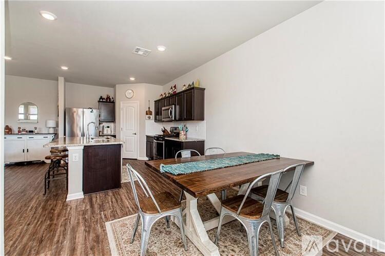 A kitchen with a table and chairs in the foreground.