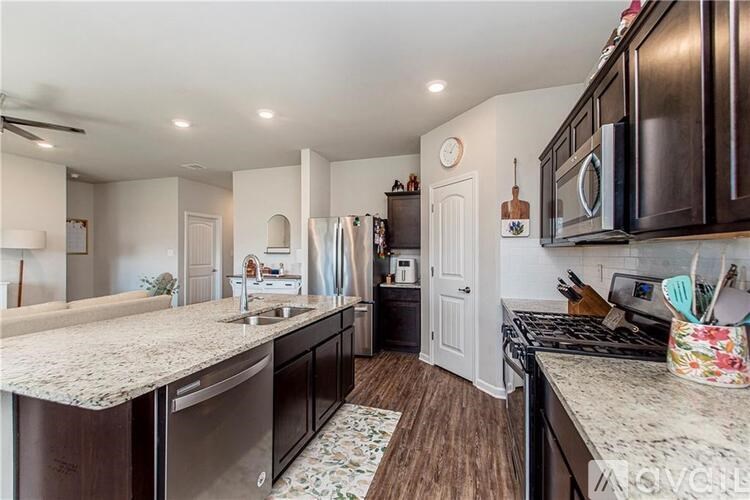 A kitchen with dark wood cabinets and a marble countertop.