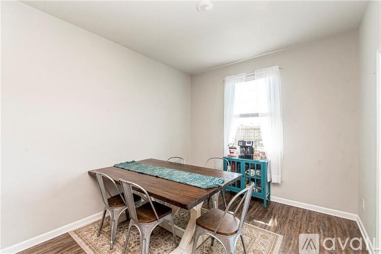 A dining room with a table and chairs.