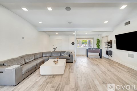 A modern living room with a grey sofa and a white coffee table.