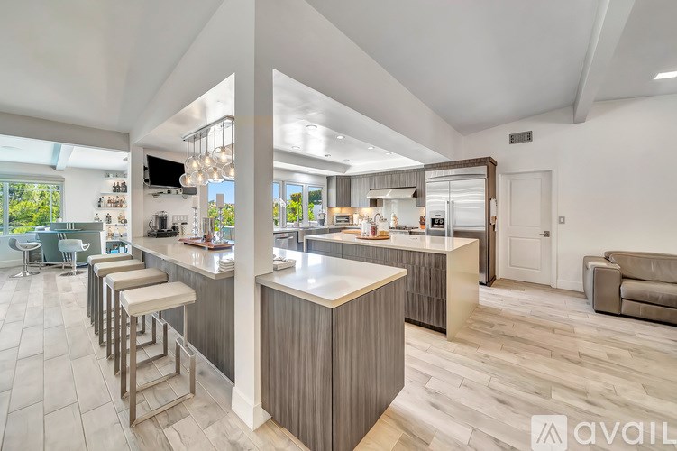A modern kitchen with a bar area and a dining area.