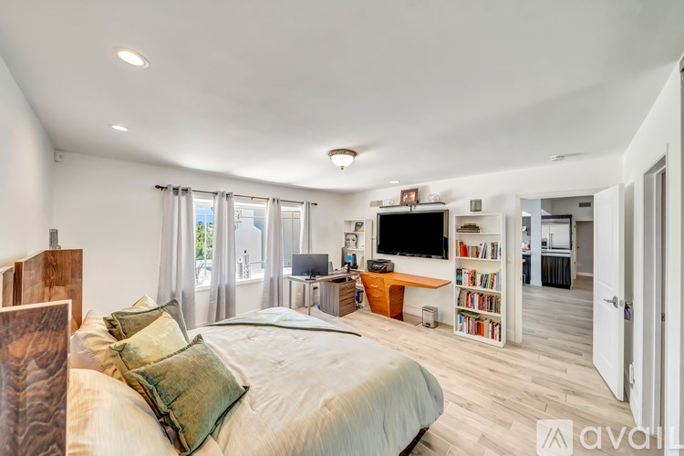 A bedroom with a large bed and a television in the corner.