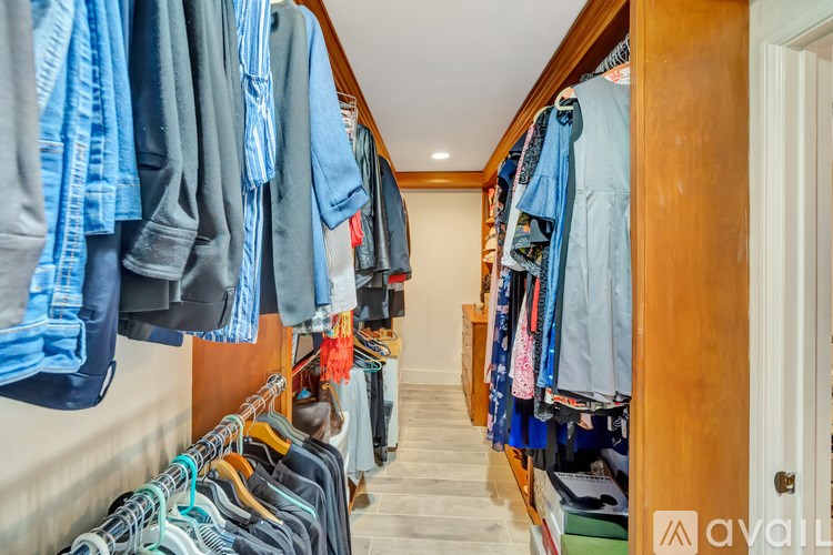 A row of clothes hangs on a rack in a room.