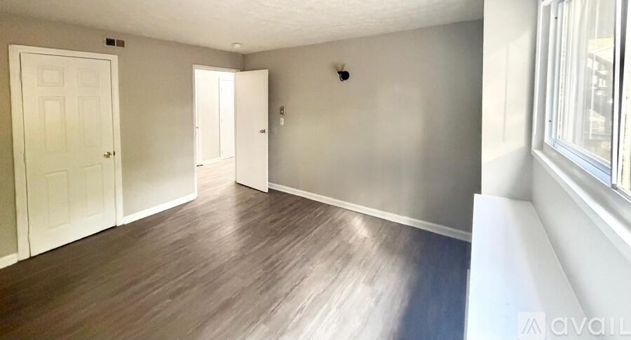 A room with wooden flooring and white walls.