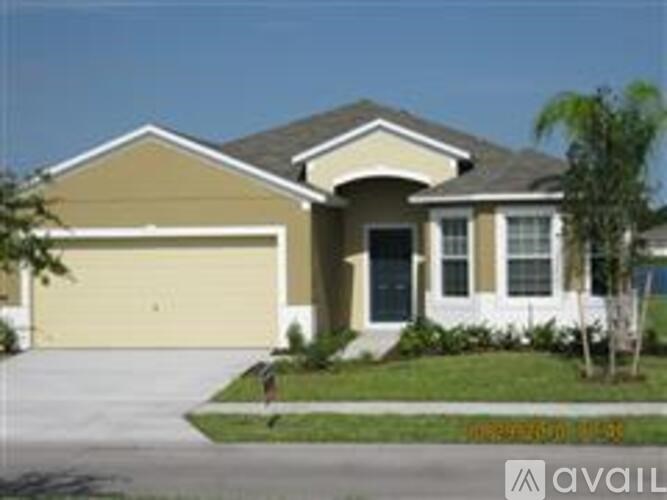 A beige house with a black door and a garage door.