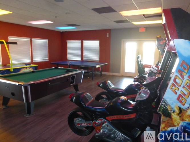 A room with a pool table and a motorcycle.