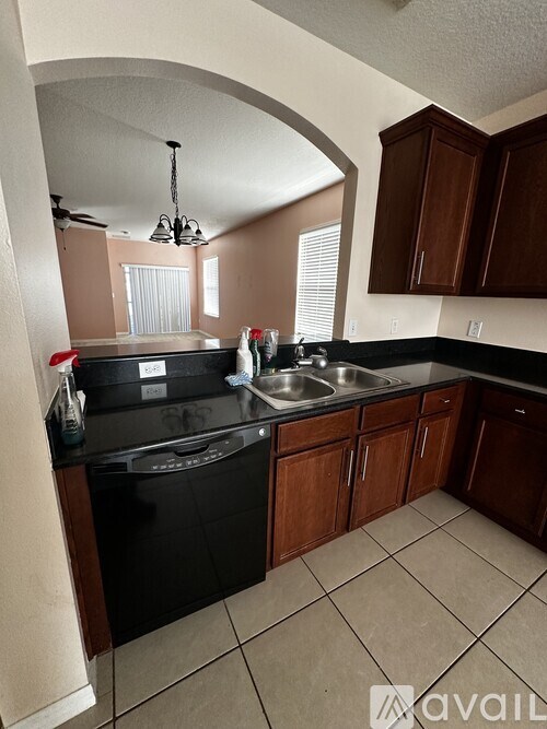 A kitchen with black appliances and brown cabinets.