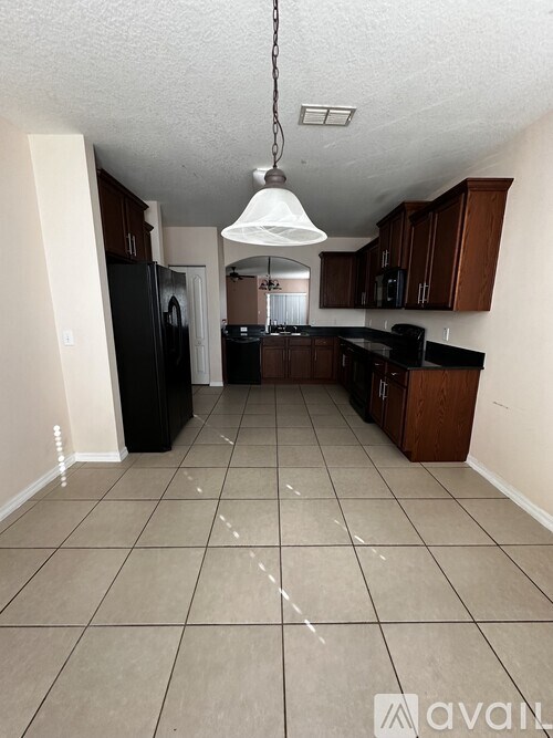 A kitchen with black appliances and brown cabinets.