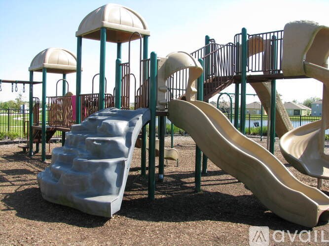 A playground with a blue slide and a brown slide.