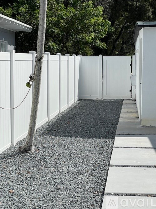 A white fence with a tree growing out of it.