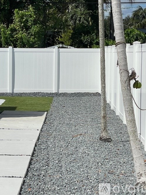 A white fence with a tree in front of it.