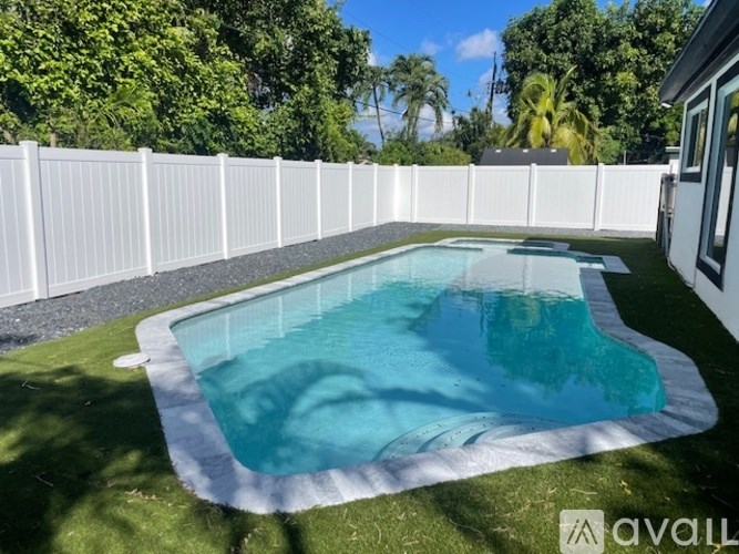 A small above ground pool surrounded by a white fence.