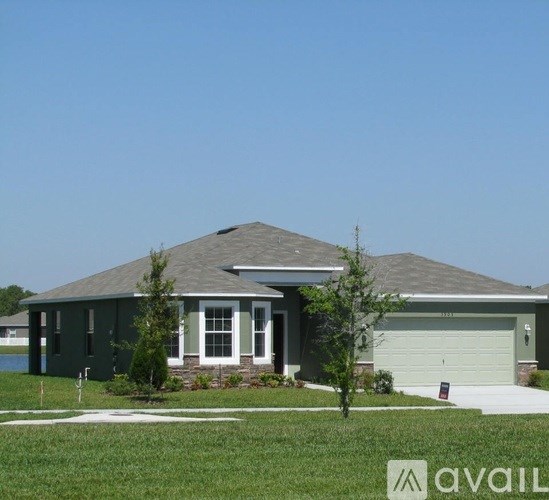 A house with a green front yard and a clear blue sky.