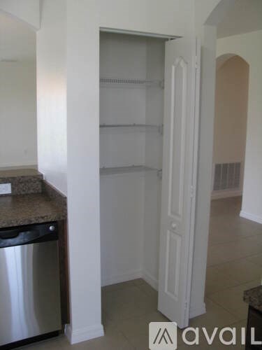 A kitchen with a granite counter top and a dishwasher.