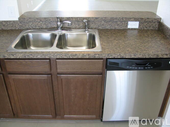 A kitchen with a granite countertop and a stainless steel dishwasher.
