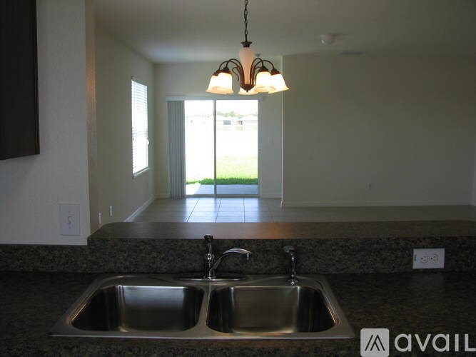 A kitchen with a sink and a chandelier.