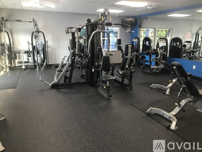 A gym with a variety of equipment including treadmills, weights, and exercise machines.