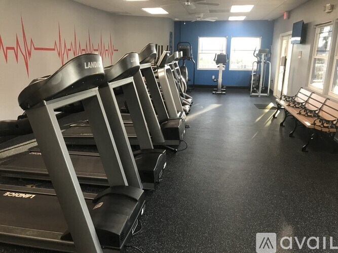 A gym with treadmills and a heartbeat line on the wall.