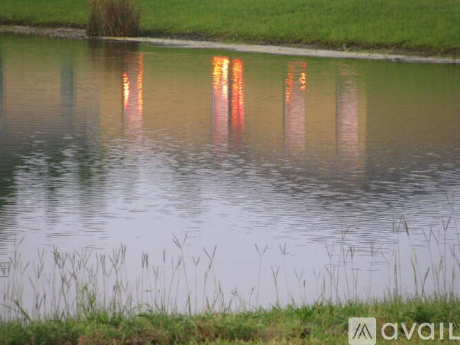 A calm body of water reflects the surrounding greenery.