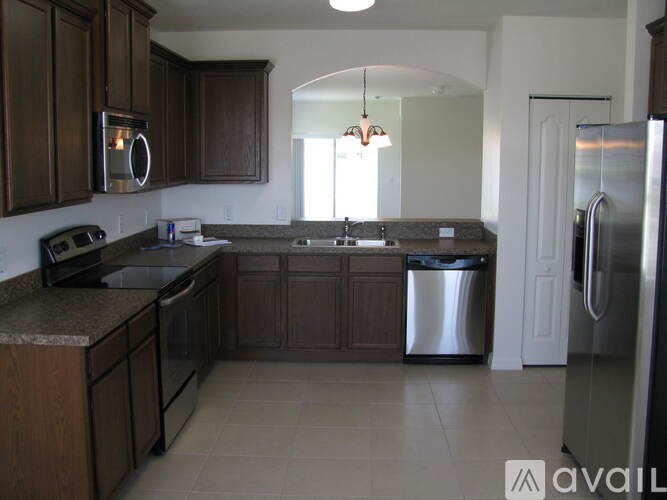 A kitchen with brown cabinets and a granite countertop.