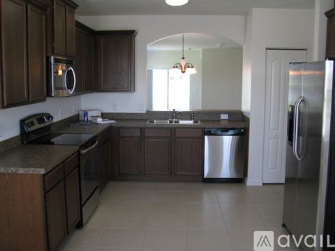 A kitchen with brown cabinets and a granite countertop.