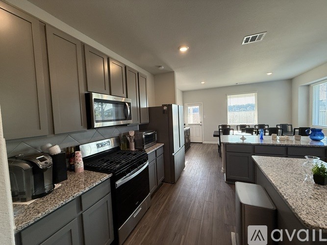 A modern kitchen with dark wood cabinets and stainless steel appliances.