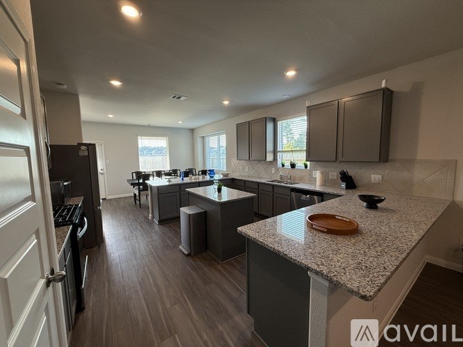 A kitchen with a granite countertop and wooden flooring.