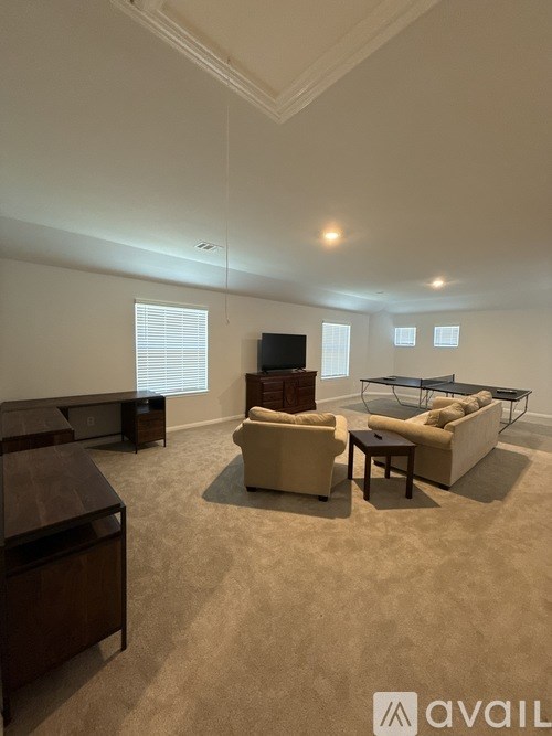 A living room with a sofa set, a coffee table, and a television.