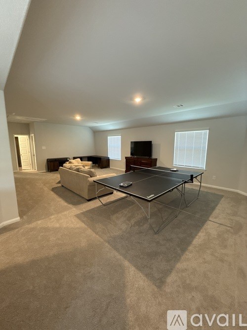 A living room with a sofa, a coffee table, and a television.