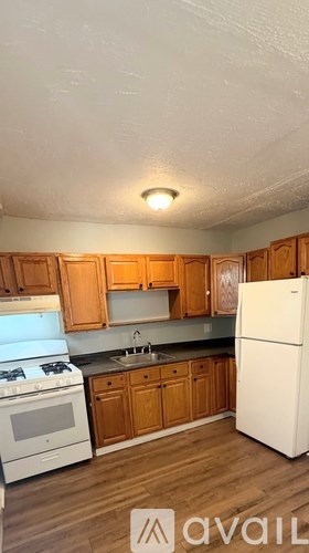A kitchen with wooden cabinets and white appliances.