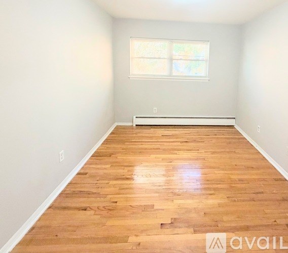 A room with wooden flooring and a window.