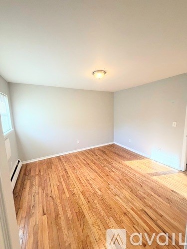 A room with wooden flooring and white walls.