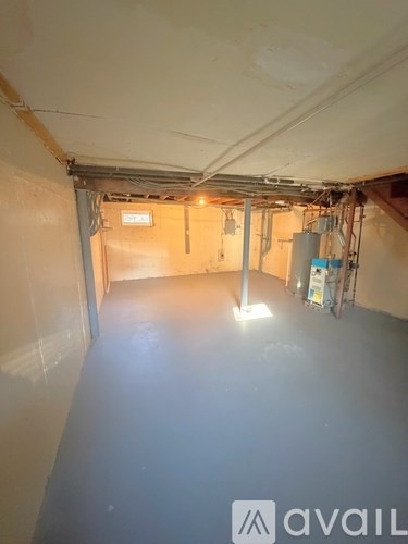 A large empty room with a sign that says "avail" on the wall.