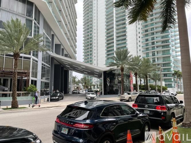 Cars are parked on the side of the road in front of a building.