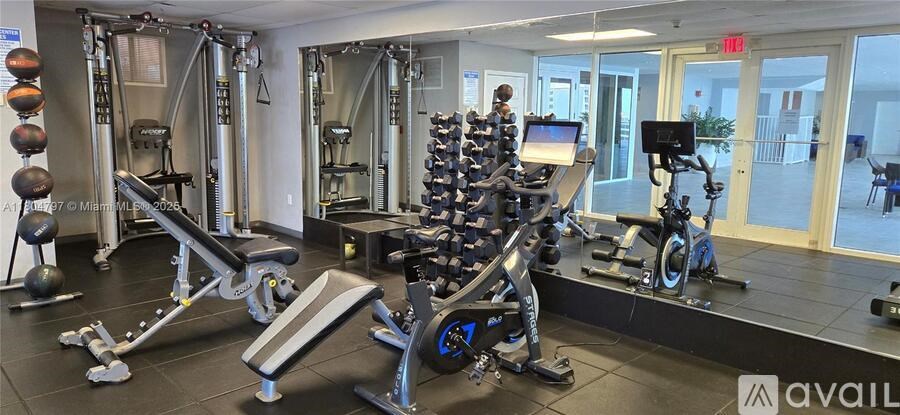 A gym with a variety of equipment including a leg press machine, a squat rack, and a treadmill.
