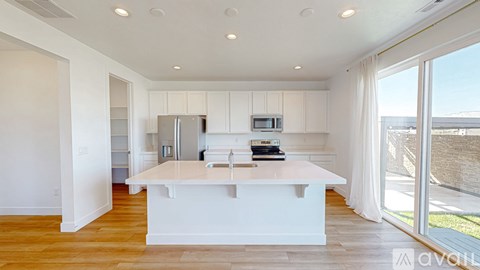 A kitchen with white cabinets and a white island with a book on top.