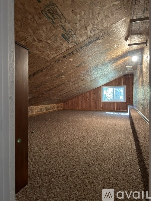 A room with a brown carpet and wooden walls.