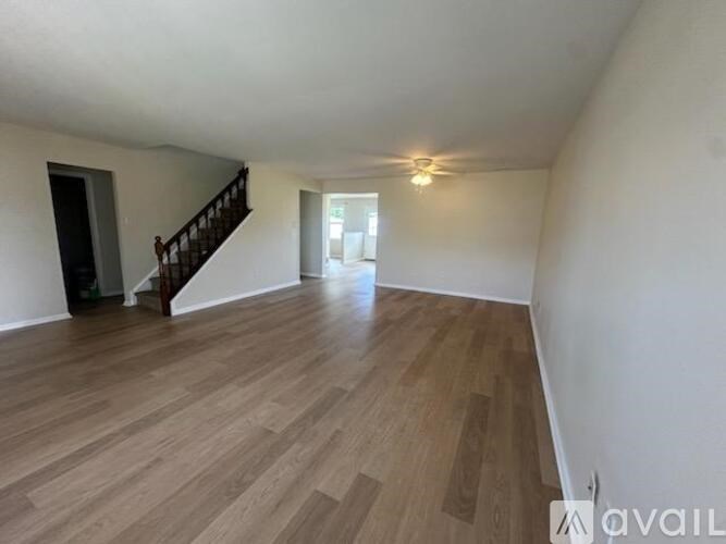 A room with wooden flooring and a staircase.