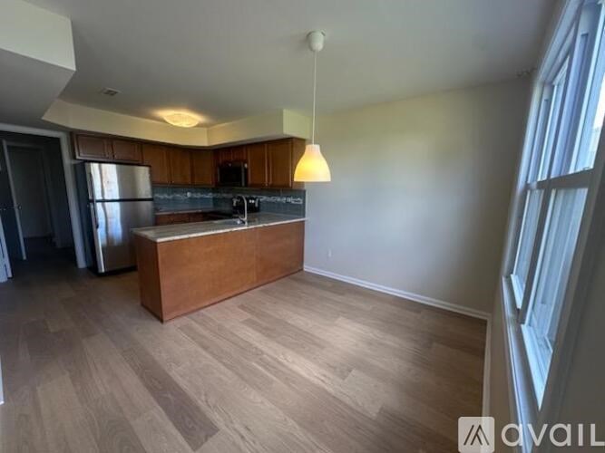 A kitchen with a refrigerator, sink, and cabinets.