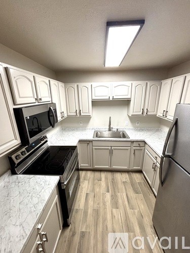 A kitchen with wooden floors and white cabinets.
