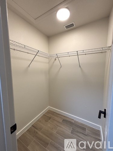 A hallway with a white wall and a wooden floor.
