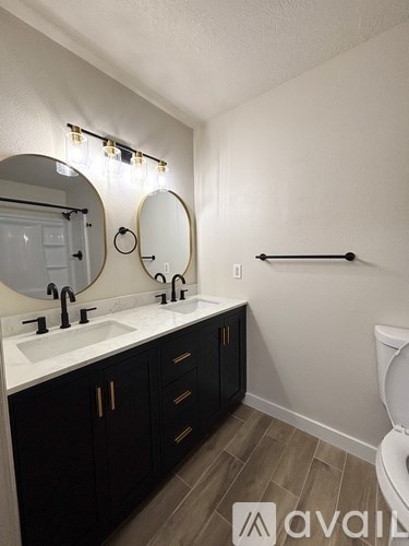 A bathroom with a white sink and black cabinets.