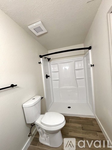 A white toilet in a small bathroom with a white door.