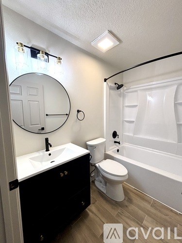 A bathroom with a sink, toilet, and bathtub.