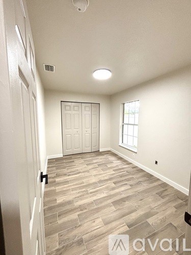 A room with a wooden floor and a white door.